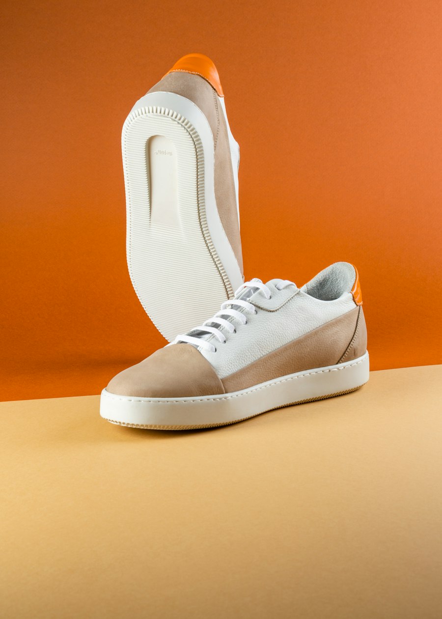 Beige and white leather sneakers with orange heel tab
